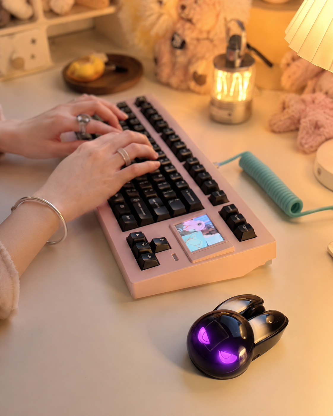 Person typing on a pink keyboard next to a black evil bunny mouse with purple glowing eyes